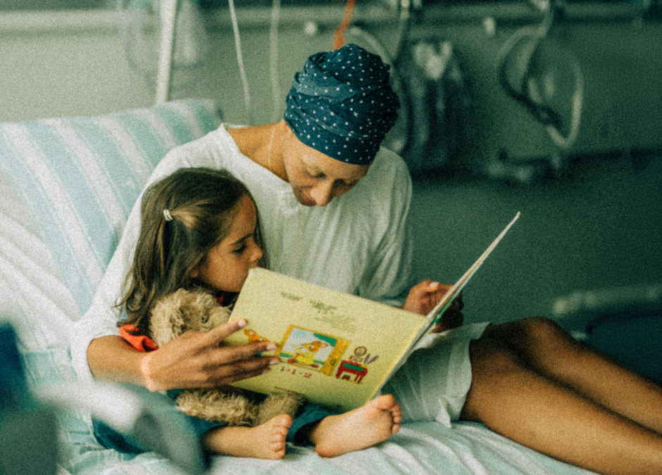ett barn och en mamma i en sjukhussäng som läser bok